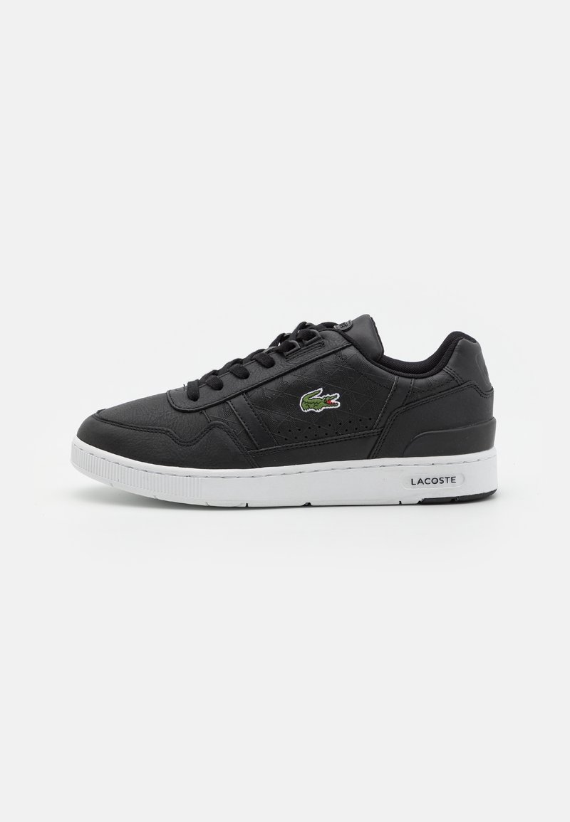 Baskets basses Lacoste noires avec semelle blanche, lacets et logo crocodile vert sur le côté, vues de l'extérieur.