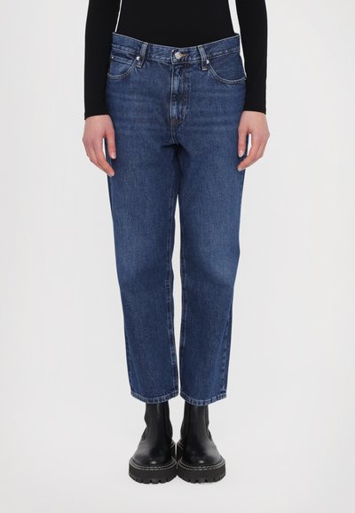 Classic kék farmernadrág, amely denim anyagból készült, magas derekú, egyenes lábú fazonnal, négy zsebbel és diszkrét varrási részletekkel.