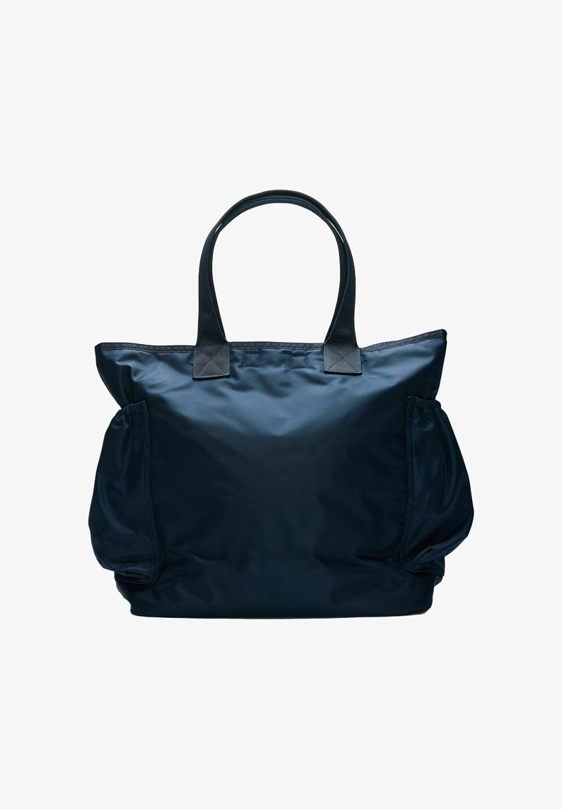 Grand sac cabas noir avec double poignée et deux poches latérales froncées, en tissu nylon lisse.