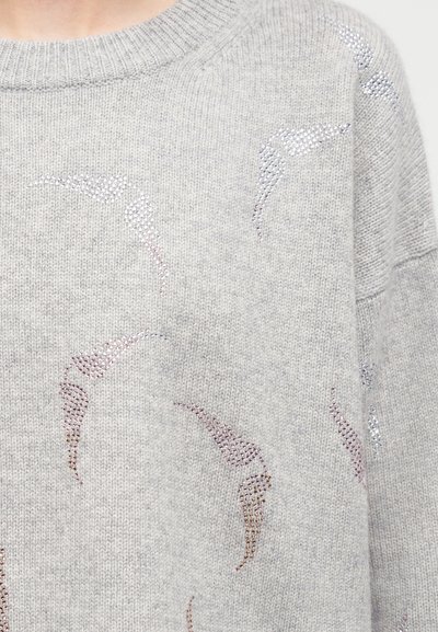 Ανοιχτό γκρι πλεκτό πουλόβερ με διάσπαρτα λαμπερά μοτίβα από στρας που μοιάζουν με αφηρημένα πουλιά σε πτήση στο μπροστινό μέρος και στον ώμο.