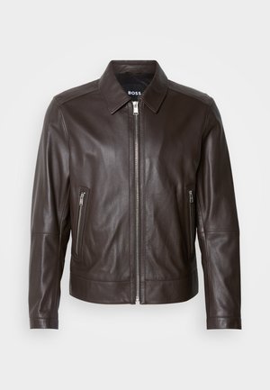 Brown leather jacket with a smooth texture, a collar, zippered front closure, and two zippered side pockets. Accent stitching visible.
