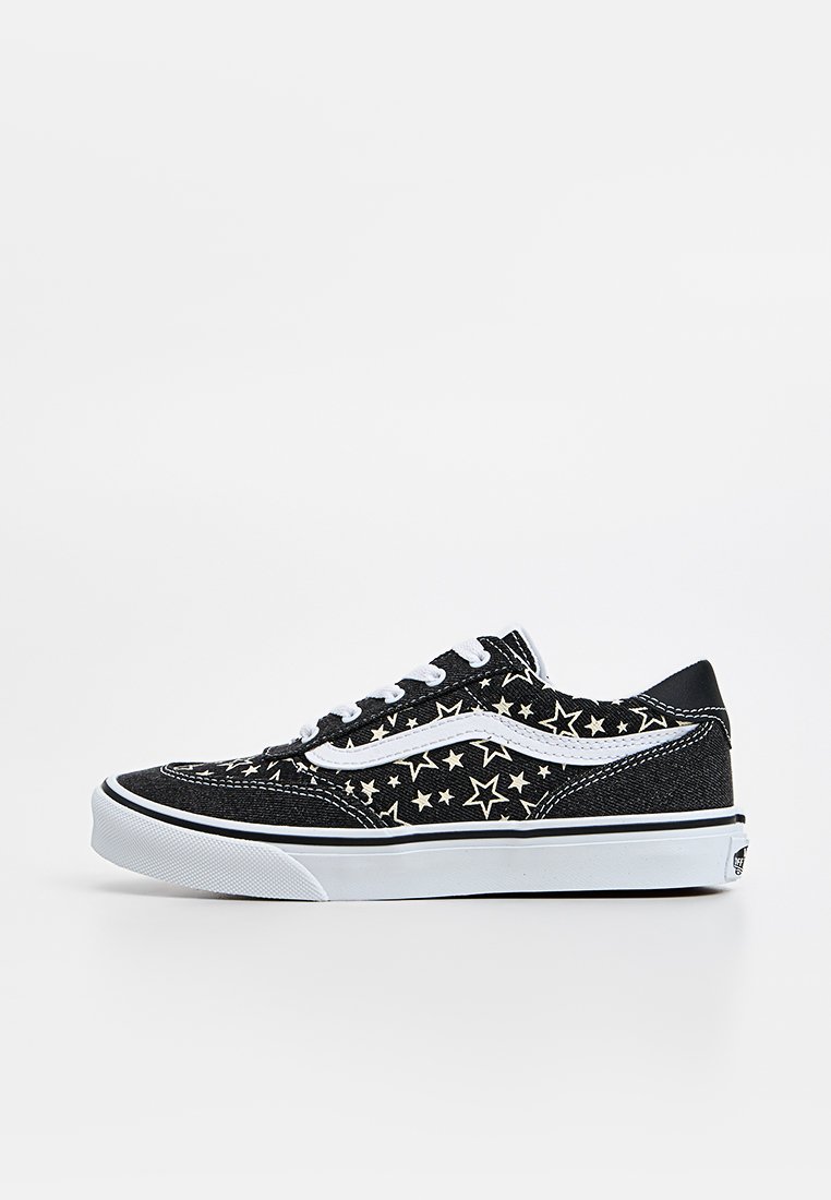 Zapatillas de lona negras con patrones de estrellas blancas, detalles blancos y suelas de goma negras. Diseño clásico con cordones y perfil bajo.