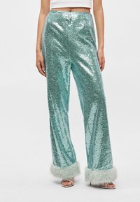 Μπλε τζιν παντελόνι με ανοιχτό γκρι φουντωτό trim στον καρπό, σχεδίαση με φαρδιά πόδια και λαμπερή, υφασμάτινη επιφάνεια.