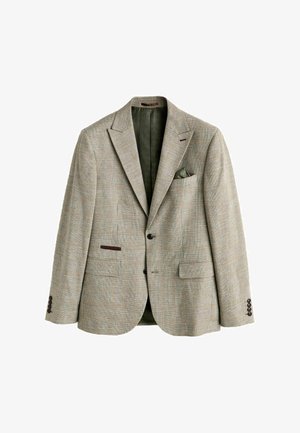 Beiger kariert Herrenblazer mit zwei Knöpfen, Stegkragen, Pattentaschen und Leistentaschen sowie einem dunkelgrünen Einstecktuch in der Brusttasche.