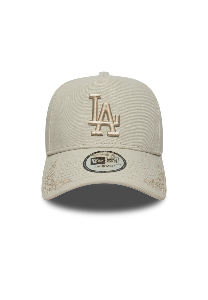 Beige kasket med et struktureret design, der har et hævet beige "LA" logo, tekstureret stof og en buet skygge. Justerbar rem synlig.