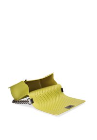 Geel rubberen tas met een geperforeerd oppervlak, voorzien van een kettinghandvat en een hoekig ontwerp. De tas heeft een unieke, opvouwbare structuur.