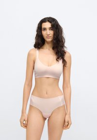 Ανοιχτόροζ ασύρματο σουτιέν με λεπτές τιράντες και λεία υφή, σετ με ταιριαστά σλιπ ψηλόμεσα από παρόμοιο υλικό και χρώμα.