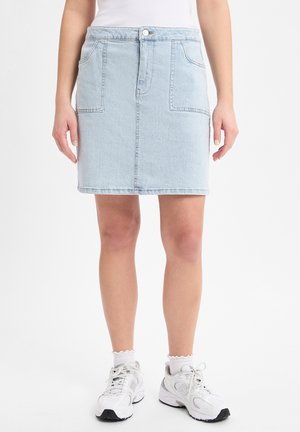 Light blue denim pencil skirt with two front pockets, a button closure, and a clean hem, worn with white sneakers and socks.