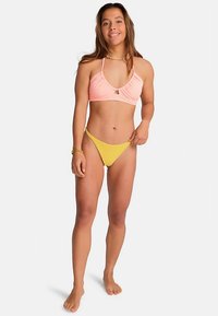 Badpakset bestaande uit een roze bralette met een keyhole-detail en dunne bandjes, gecombineerd met gele, hooggesneden bikinibroekjes.