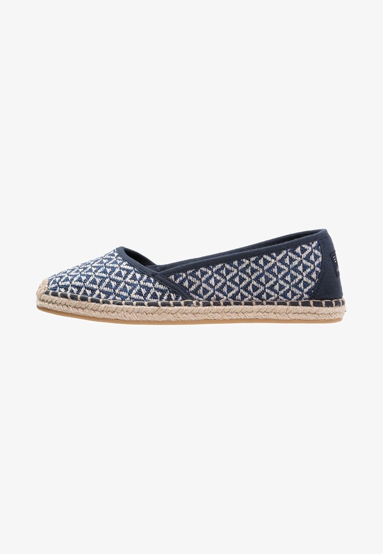 Espadrille bleu marine avec un motif géométrique, fabriquée en tissu et en jute. Présente une semelle plate et un design classique à enfiler.