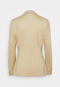 Blazer beige su misura con maniche lunghe, spacchetto singolo sul retro e polsini con bottoni, mostrato di spalle su uno sfondo bianco.