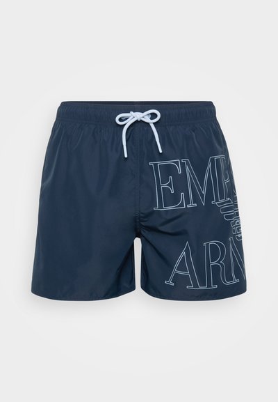 Tamsiai mėlynos maudymosi šortai, pagaminti iš lengvos medžiagos. Yra didelis baltas tekstas, elastinga juosmens juosta su raišteliu ir šoniniai kišeniai.