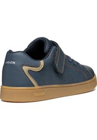 Sneaker in pelle blu navy con un accento in pelle marrone, dotato di una fascetta in velcro, punta rotonda, suola in gomma testurizzata e perforazioni per la traspirabilità.