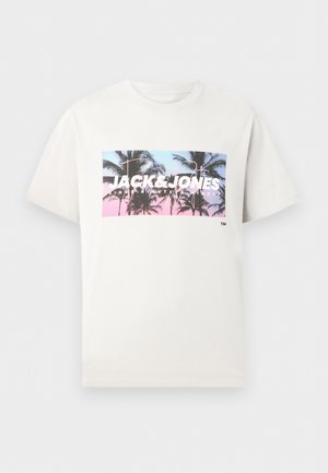 Hvit T-skjorte med korte ermer, med et rektangulært motiv av palmetrær mot en rosa og blå himmel, samt teksten "JACK & JONES".