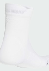 Calzino bianco alla caviglia realizzato in materiale testurizzato, con un design a maglia stretta e un bordo a coste per una vestibilità sicura. Nessun motivo o accentuazione visibile.