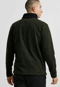 Fleece pullover in donkergroen met een zwarte kraag, voorzien van een gestructureerde afwerking, lange mouwen en een relaxte pasvorm, ideaal voor het laagjes dragen.