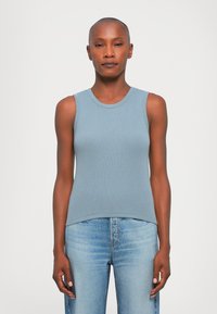 Light blue ribbed tank top with a round neck and fitted design, paired with light blue jeans, creating a casual, coordinated outfit.