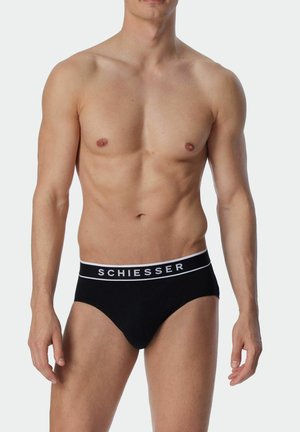 Schwarze Unterhosen aus weicher Baumwolle mit einem weißen Logobund. Verfügt über eine enganliegende Passform und ein minimalistisches Design. Glatte Textur ohne Muster.