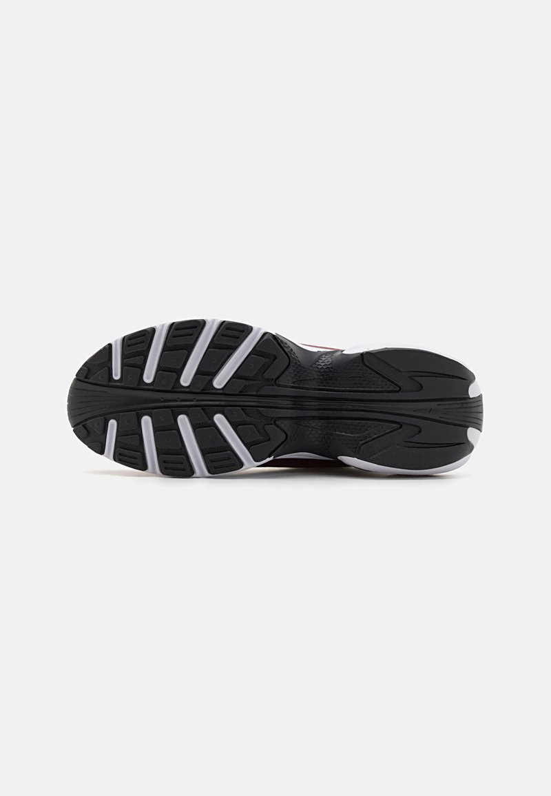Sole di una scarpa sportiva nera con un motivo di battistrada distintivo. Caratterizzata da materiale in gomma, superficie testurizzata e accenti bianchi lungo i lati.