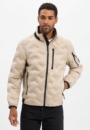 Beige gesteppte Jacke aus leichtem Material, mit einem Reißverschluss vorne, hohem Kragen und seitlichen Taschen mit schwarzen Akzenten.