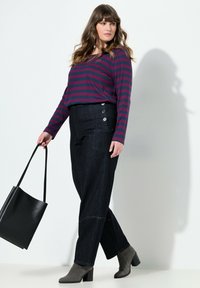 Pruhovaná košile s dlouhým rukávem v burgundské a námořnické modři, kombinovaná s tmavými džíny s bočními knoflíky a uvolněným střihem, doplněná šedými kotníkovými botami.