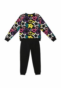 Czarny sweter z kolorowym, abstrakcyjnym wzorem gwiazd, serc i uśmiechów; w połączeniu z jednolitymi czarnymi dresami.