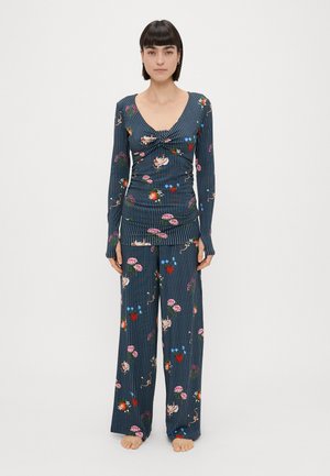 Ensemble de pyjama rayé en bleu marine avec des motifs floraux. Manches longues et pantalon large, présentant des couleurs vives et un tissu doux et texturé.