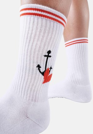 White cotton socks with ribbed texture, featuring orange stripes at the top and an embroidered black anchor with a red heart design.
