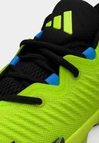 Αθλητικό παπούτσι σε νεανικό πράσινο χρώμα με υφή στην επιφάνεια, μαύρα κορδόνια, μπλε λεπτομέρειες και σχεδιασμό με μοτίβο. Διαθέτει εμφανές λογότυπο στη γλώσσα.