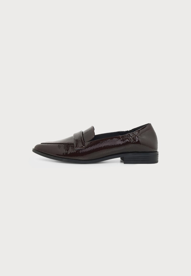 Mocassin en cuir marron foncé brillant avec petit talon et bout arrondi, doté d'une large bride sur le cou-de-pied.