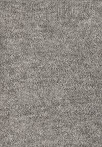 Gros plan d'un tissu tricoté doux et gris avec une texture duveteuse et des détails fins de fil.