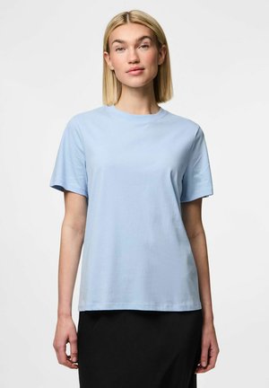 Camiseta de manga corta color azul claro, hecha de una tela suave, con un escote redondo y un corte relajado, combinada con una parte inferior negra.