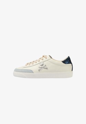 Baskets en cuir blanc avec des accents en daim bleu clair, présentant un logo de crâne argenté et un talon pailleté bleu foncé. Lacets beige et semelle texturée.