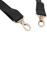 Black strap made of textured material, featuring gold-tone metal clips at each end for attachment. Simple design with no patterns.