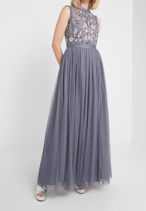 Robe sans manches lavande avec un corsage brodé de fleurs et une jupe fluide en tulle, portée avec des talons à plateforme argentés.