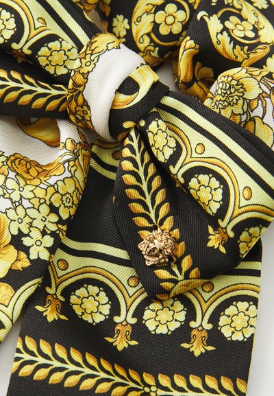 Schwarzer Schal mit gelbem und grünem Blumenmuster, ausgestattet mit einem goldenen Löwen-Hardware-Akzent und komplizierten Designelementen, die mit Blättern verflochten sind.