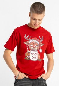 Czerwona bawełniana koszulka z nadrukiem kreskówkowego renifera w czapce Mikołaja, trzymającego kubek z napisem "HOOF OFF", z zielonymi i białymi akcentami.