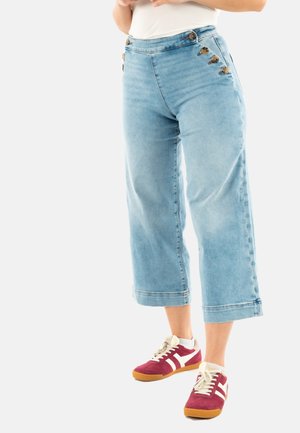 Pantalones cortos de mezclilla azul claro con cintura alta y detalles de botones, que presentan un diseño de pierna recta y costuras visibles a lo largo del dobladillo.