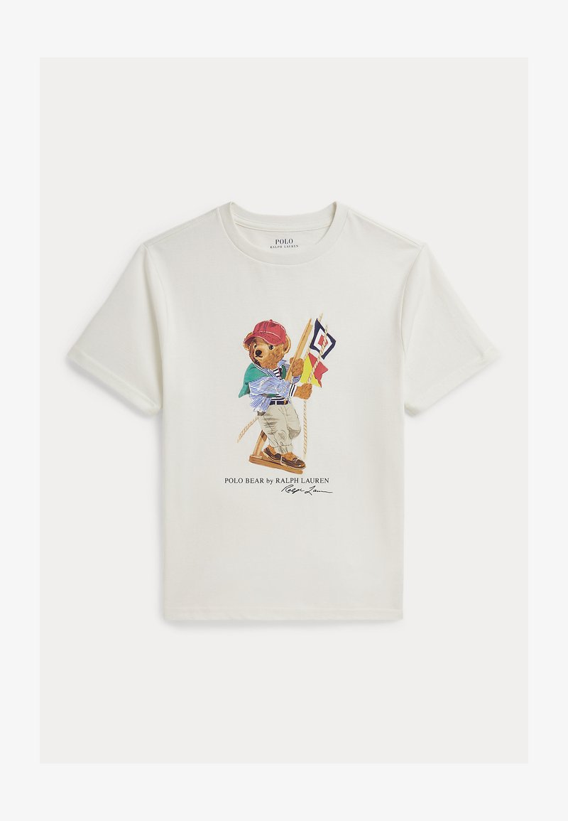 Λευκό κοντομάνικο μπλουζάκι με εικόνα αρκούδας που φοράει κόκκινο καπέλο, ριγέ πουκάμισο, χακί παντελόνι και κρατάει ναυτικούς σημαίες σε μια κούνια.