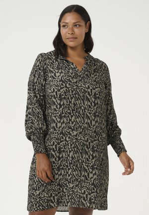 Abito nero e beige con motivo, scollatura a V, maniche lunghe a sbuffo e polsini arricciati; tessuto leggero con una silhouette fluida.