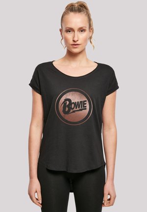 Schwarzes T-Shirt mit kurzen Ärmeln und einem runden kupferfarbenen Grafik, die den Text „Bowie“ in fetter schwarzer Schrift zeigt, entspannter Schnitt, weiche Textur.