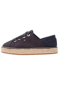 Námořnické plátěné espadrilky s kulatou špičkou, tkanou juteovou podrážkou, zlatými očky a logem na patě. Lehký a neformální design.