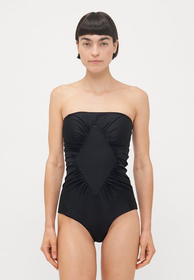 Sort strapless one-piece badedragt med rynket stof og en diamantformet pynt i midten. Glat tekstur, tætsiddende design.