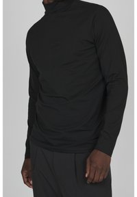 Svart långärmad polotröja i mjukt tyg, med en slim fit och diskret textur, ribbad krage och jämn yta.