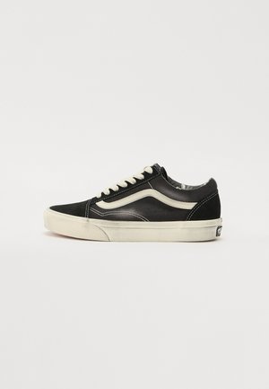 Adidași din suede negru cu șireturi albe, talpă din cauciuc, design clasic, vârf rotunjit și detaliu distinct de dungi pe lateral. Superior din material texturat.