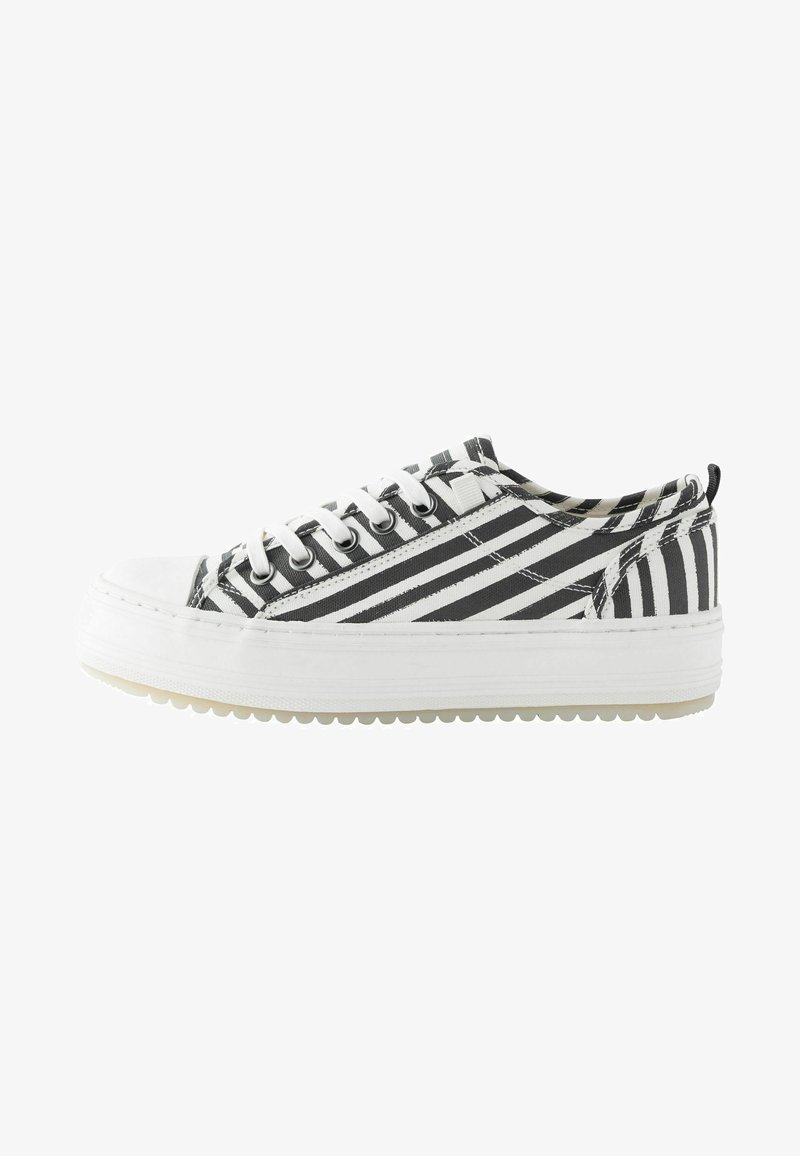 Zapatillas de lona a rayas en blanco y negro con punta redonda, suela de goma blanca y ojetes metálicos, que presentan un diseño con cordones.