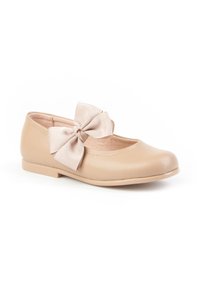 Bailarinas de piel beige con un gran lazo de tela en el lateral y un tacón bajo, diseñadas para niñas.