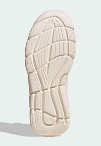 Suela de zapato con un material de goma texturizado de color beige claro y varios patrones de banda de rodadura para tracción y soporte.