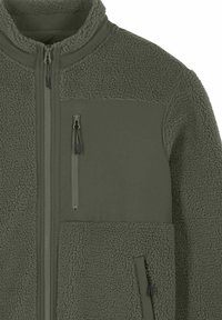 Veste en polaire vert olive avec un panneau lisse, une poche poitrine zippée et des poches latérales. Tissu doux et texturé pour plus de chaleur.