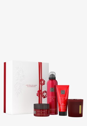 Cadeauset met witte doos met rood bloemmotief en lint. Bevat vier rode producten: bodyscrub, bodycrème, doucheschuim, kaars.